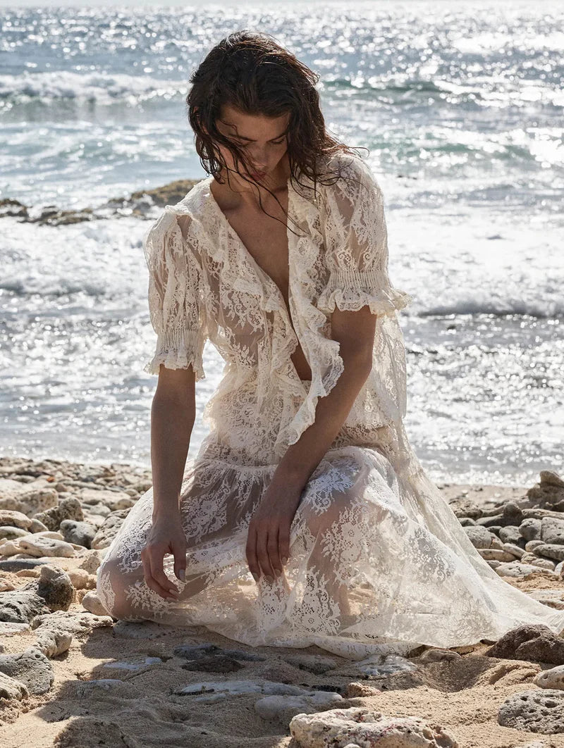 The Henri Lace Top in Sea Salt by Doen brings timeless elegance to your wardrobe with its intricate chantilly-inspired lace and romantic Edwardian details. A plunging V-neckline is beautifully framed by cascading lace-trimmed ruffles that flow down the bodice, while delicate clustered pintucks add texture to the yoke, back, and short puffed sleeves. Hidden starburst buttons line the center front for a polished finish. 