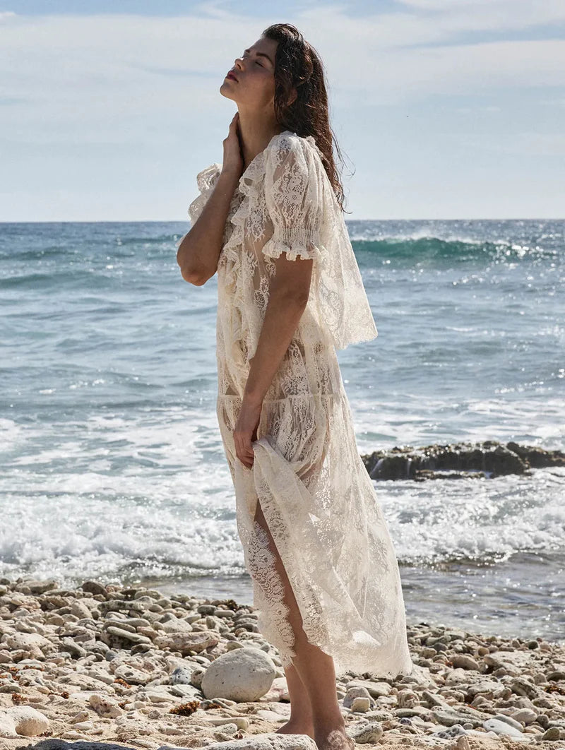 The Henri Lace Top in Sea Salt by Doen brings timeless elegance to your wardrobe with its intricate chantilly-inspired lace and romantic Edwardian details. A plunging V-neckline is beautifully framed by cascading lace-trimmed ruffles that flow down the bodice, while delicate clustered pintucks add texture to the yoke, back, and short puffed sleeves. Hidden starburst buttons line the center front for a polished finish. 