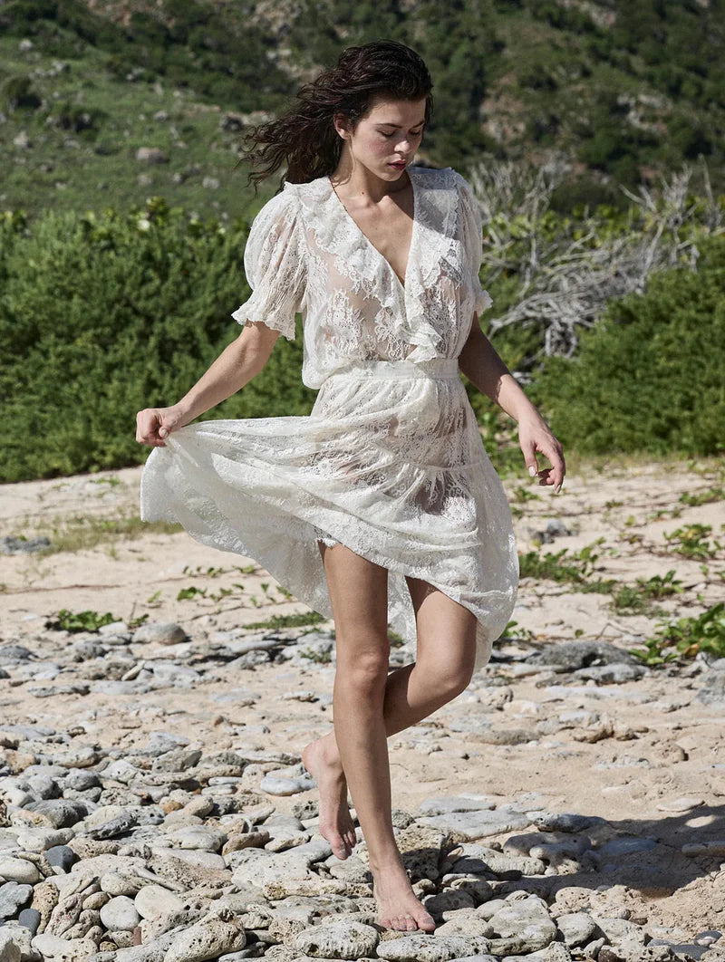 The Henri Lace Top in Sea Salt by Doen brings timeless elegance to your wardrobe with its intricate chantilly-inspired lace and romantic Edwardian details. A plunging V-neckline is beautifully framed by cascading lace-trimmed ruffles that flow down the bodice, while delicate clustered pintucks add texture to the yoke, back, and short puffed sleeves. Hidden starburst buttons line the center front for a polished finish. 