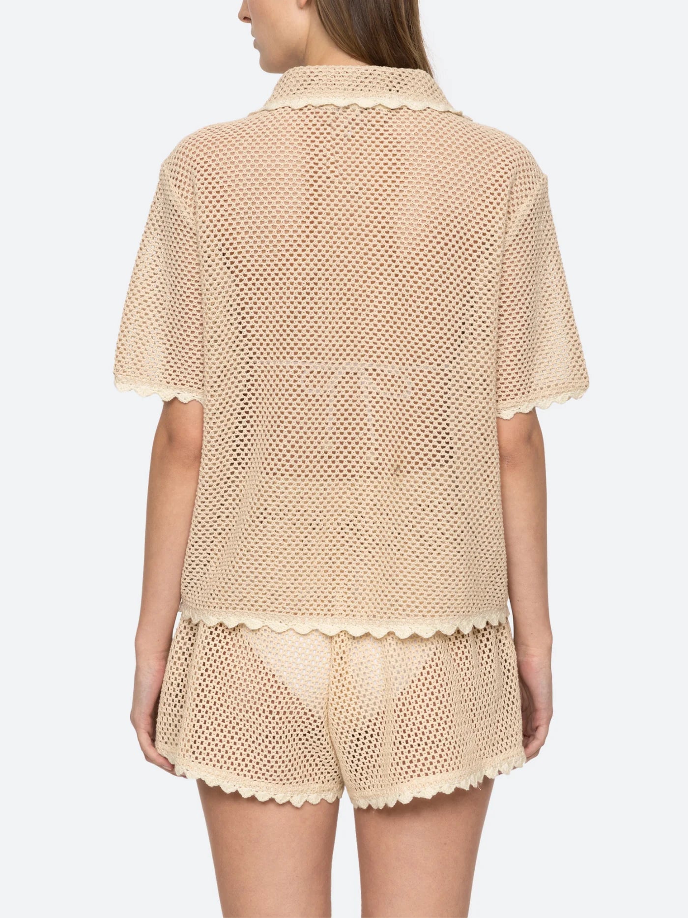 Upgrade your wardrobe with the Sally Crochet Shirt by SEA NY! This mid-weight, open knit shirt is designed for a slightly loose fit and is appliquéd with two delicate birds. Traced with scalloped trims, this beige and white crocheted cotton shirt is both stylish and comfortable. Button fastenings add a polished touch, making it perfect for any occasion.