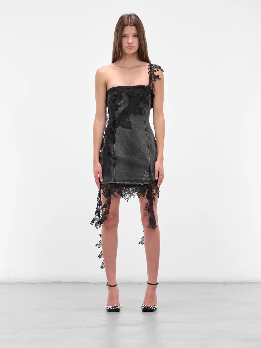 The Black Denim Mini Dress by Blumarine will elevate your edge blending rebellious style with refined details. Intricate lace draping cascades across the entire silhouette, while strategic distressing and frayed accents create an effortlessly undone aesthetic. The sleek straight neckline and delicate single lace strap define your shoulders, while the slim fit flatters your frame. 