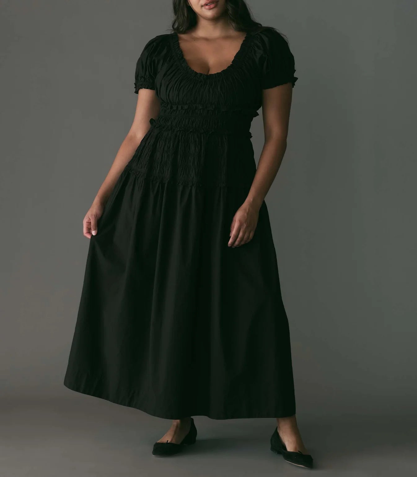 Crafted from crisp organic cotton poplin, the Leanne Dress features a scoop neckline, a gathered bust, and a fitted bodice framed with petite ruffles. A third gathered panel finishes just below the hips, flaring out into an ankle-length skirt, while elastic lends give to the short puffed sleeves, bust, and waist.