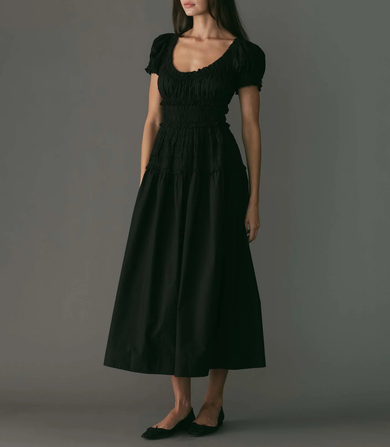 Crafted from crisp organic cotton poplin, the Leanne Dress features a scoop neckline, a gathered bust, and a fitted bodice framed with petite ruffles. A third gathered panel finishes just below the hips, flaring out into an ankle-length skirt, while elastic lends give to the short puffed sleeves, bust, and waist.