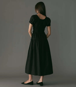 Crafted from crisp organic cotton poplin, the Leanne Dress features a scoop neckline, a gathered bust, and a fitted bodice framed with petite ruffles. A third gathered panel finishes just below the hips, flaring out into an ankle-length skirt, while elastic lends give to the short puffed sleeves, bust, and waist.