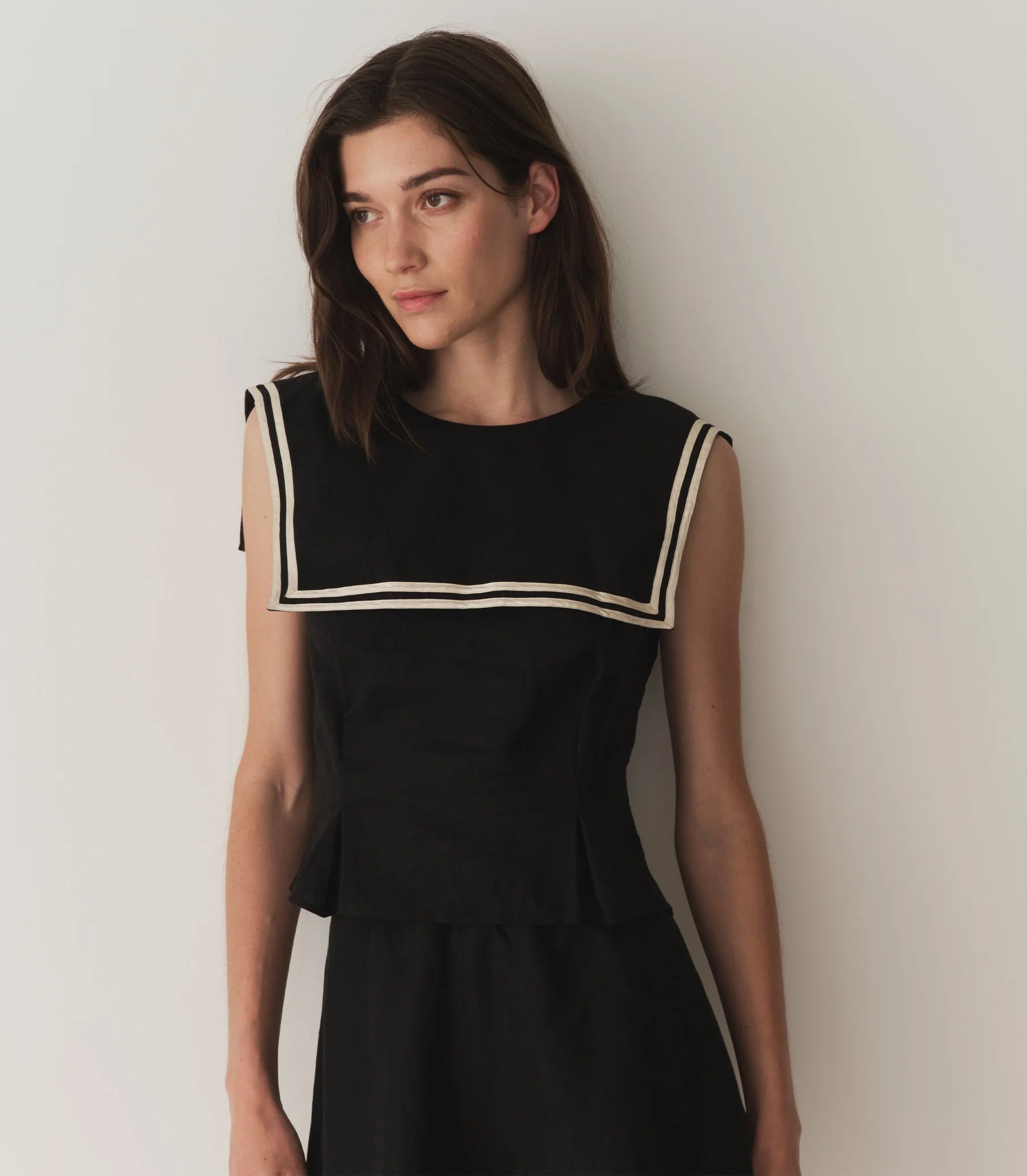 Tailored in soft midweight linen, the ‘60s-inspired Margie Top is a sleeveless style with a wide square sailor-style collar trimmed with contrast satin piping. A fitted silhouette is adorned with waist darts and box pleats for structure, while self-covered buttons extend down the back.