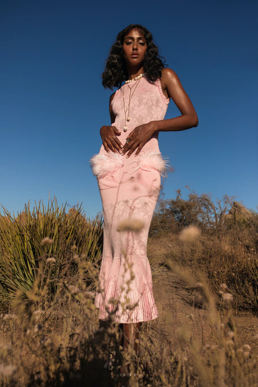 Make a statement with Andreeva's Knit Midi Dress, adorned with delicate feathers. The elegant round neck and figure-flattering design exude sophistication, perfect for any occasion. Elevate your style with heels or go for a more casual look with sandals or sneakers. Be confident and chic in this must-have dress.