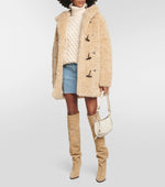 Load image into Gallery viewer, Elevate your style with ease and comfort in this Marant Etoile hooded coat. Crafted with ultra-soft faux-fur and a cozy funnel neck, this beige coat features toggles and side pockets for a functional touch. Perfect for a chic and effortless look. Worn by Emily in Paris.
