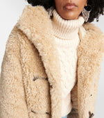 Load image into Gallery viewer, Elevate your style with ease and comfort in this Marant Etoile hooded coat. Crafted with ultra-soft faux-fur and a cozy funnel neck, this beige coat features toggles and side pockets for a functional touch. Perfect for a chic and effortless look. Worn by Emily in Paris.
