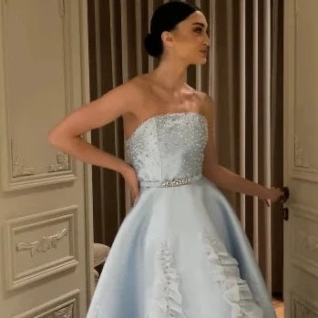 Feel elegant and glamorous in our Gown Satiya. This stunning evening dress features intricate applique and sparkling sequins, with a flattering strapless design and a beautiful sweep train. Perfect for events in Saudi Arabia or any special occasion, this dress will make you stand out and feel like a true fashionista.