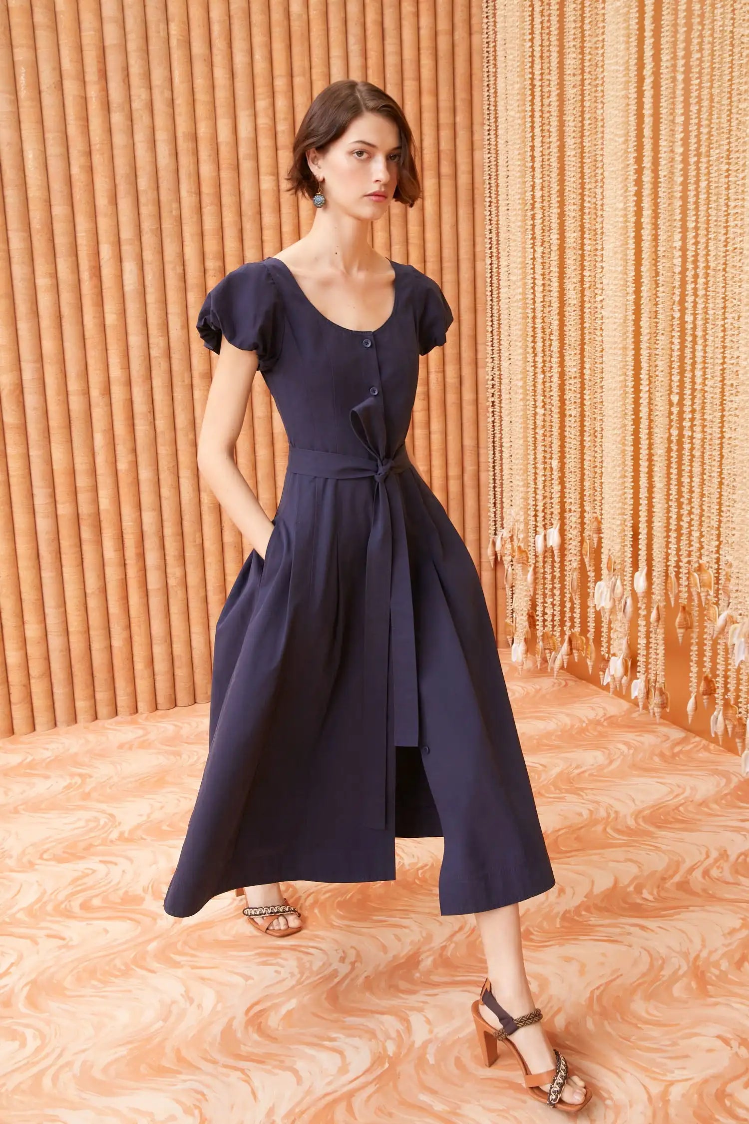 A classic Ulla Johnson silhouette perfect for daytime, the Rhea Dress is cut from our sleek cotton chino in midnight blue and is neatly tailored with corset-inspired seams. The puff sleeves feature softly rolled edges, while the removable belt at the fitted bodice adds definition. This midi-length style has side pockets and fastens with tonal buttons through the front.