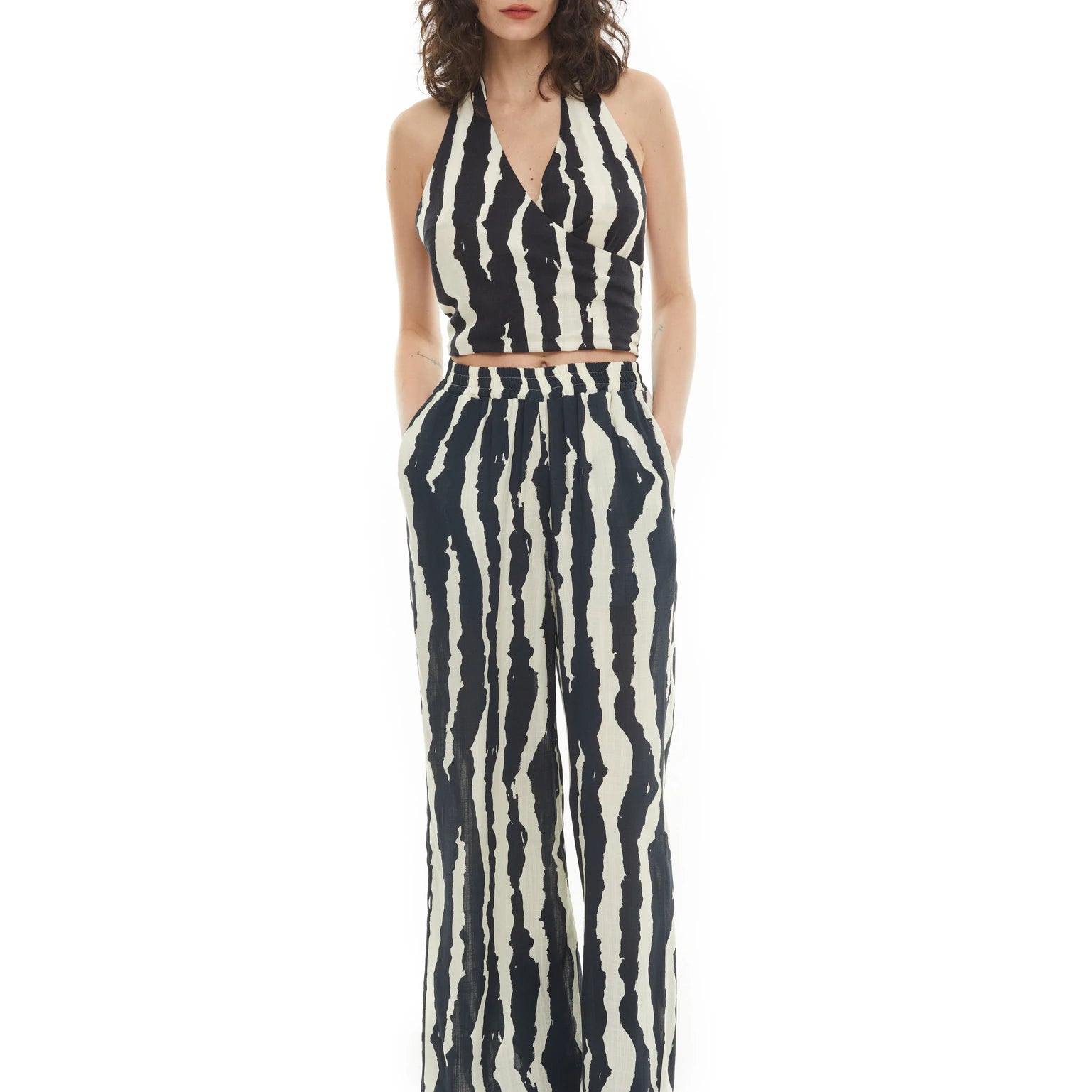 Elevate your style with the Ensemble Leigh set! Show off your back with the sexy backless halter neck top. The elastic waist and wide leg pants offer comfort and versatility, making it perfect for any occasion. Embrace your wild side with the zebra print design.