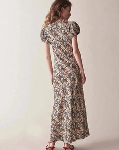 Introducing the Merla Maxi Dress, the perfect addition to your summer wardrobe. Made with viscose, this dress features a stunning floral print, short puff sleeves, and a slim fit for a flattering look. With its round neckline, it's both comfortable and stylish. Elevate your summer style with this must-have dress.