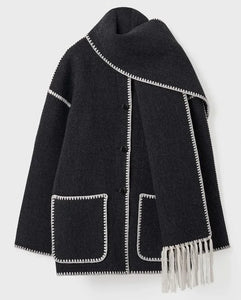 "The epitome of luxury and artistry, the Totême Veste Evelyn jacket exudes sophistication. Expertly crafted with a fringed scarf integrated into the design, this oversized wool blend jacket features dropped shoulders, wide sleeves, and contrast crochet detailing for a truly elevated look."