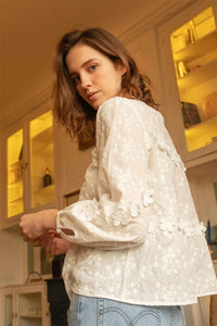 The Blouse Jenna is designed with a loose fit and intricate 3D floral embroidery for a unique and stylish look. The crisp white color adds a touch of elegance to any outfit. Upgrade your wardrobe with this must-have piece!