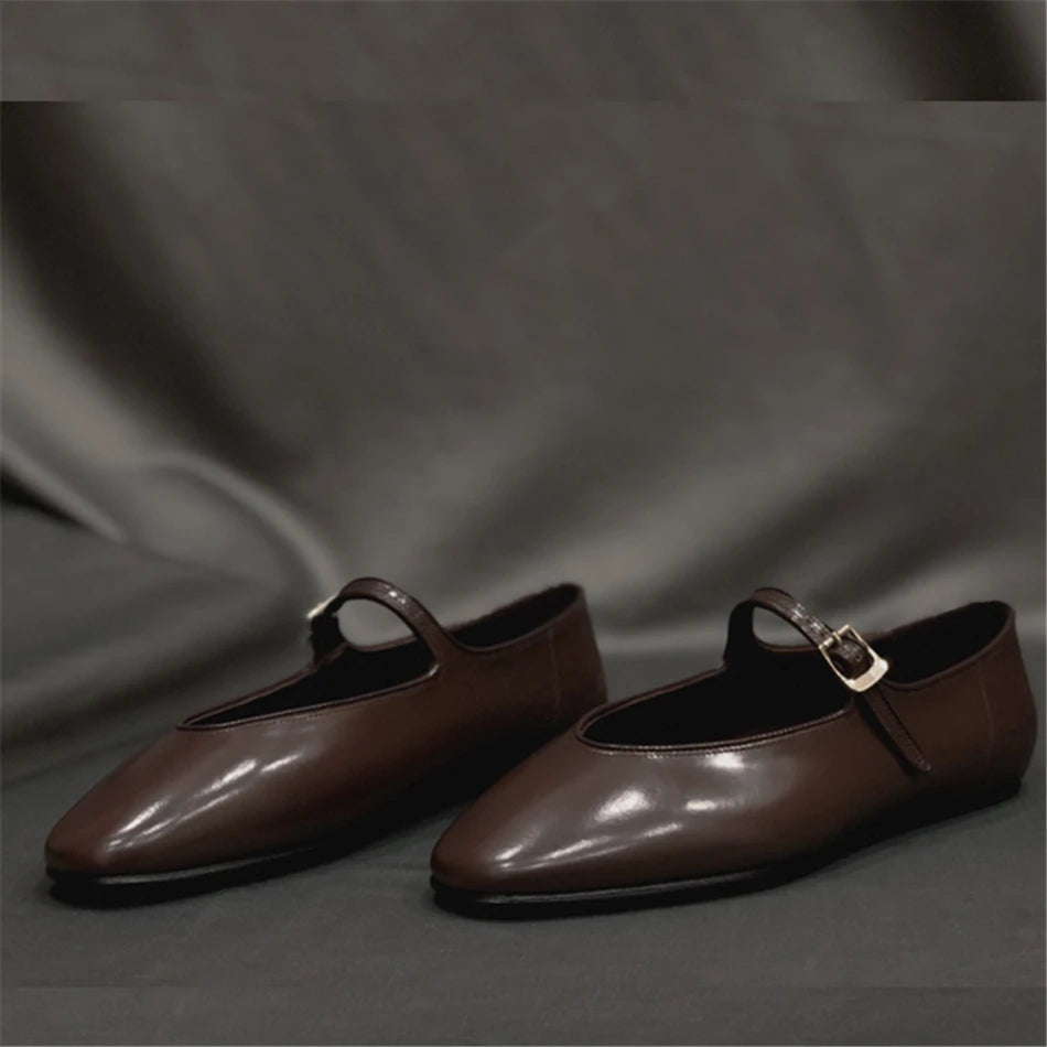 Indulge in sophistication with our Glossed-leather Mary Jane Flats. These timeless flats feature a classic silhouette and sleek almond toes, crafted from dark-brown glossed-leather. Adjustable buckled straps add versatility, making them the perfect choice to complement any outfit - from skinny jeans to tailored pieces.