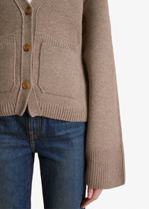 Accented by fisherman's rib trim, patch pockets and tortoiseshell buttons, this deep V-neck cardigan hugs the body in medium-weight cashmere selected for its exceptional softness and sturdy texture. The fitted silhouette is balanced by relaxed, elongated sleeves. This richly hued cardigan from Khaite in soft, sumptuous cashmere is as cozy as it is elegant. The V-neck is perfect as an off-the-shoulder piece for both day and evening wear. This cardigan has a V-neck and fastens with a button in the front. 