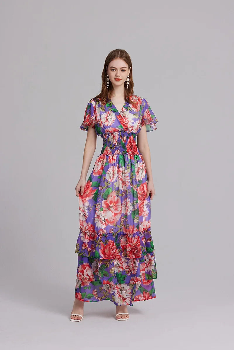 Introducing the Robe Aurora, the perfect summer dress for any occasion. Made with a beautiful floral pattern and a flattering v-neck design, this maxi dress also features an elastic waist for a comfortable fit and stylish ruffles. Stay cool and chic in this must-have piece.