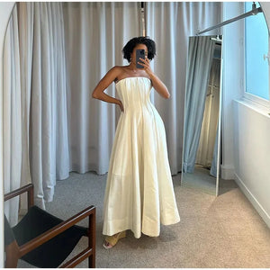 Indulge in luxury and glamour with our Jade Maxi Dress. This elegant, pleated white dress is the epitome of sophistication with its strapless design, sexy and sleeveless silhouette, and revealing open back. The oversized hem adds a touch of drama to this stunning party gown. Perfect for special occasions and making a statement.