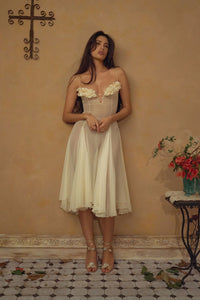 Crafted from delicate silk chiffon, the Valentina Dress in Butter features exquisite handcrafted floral appliqués precisely placed on the bust, creating a unique motif inspired by a weekly bouquet of roses. The 1/8-inch chiffon crisscross straps at the bust center add refined detail, while the dress includes a full separate lining, allowing for versatile styling options. A discreet center back zipper ensures a tailored fit, combining elegance with comfort for a sophisticated silhouette.