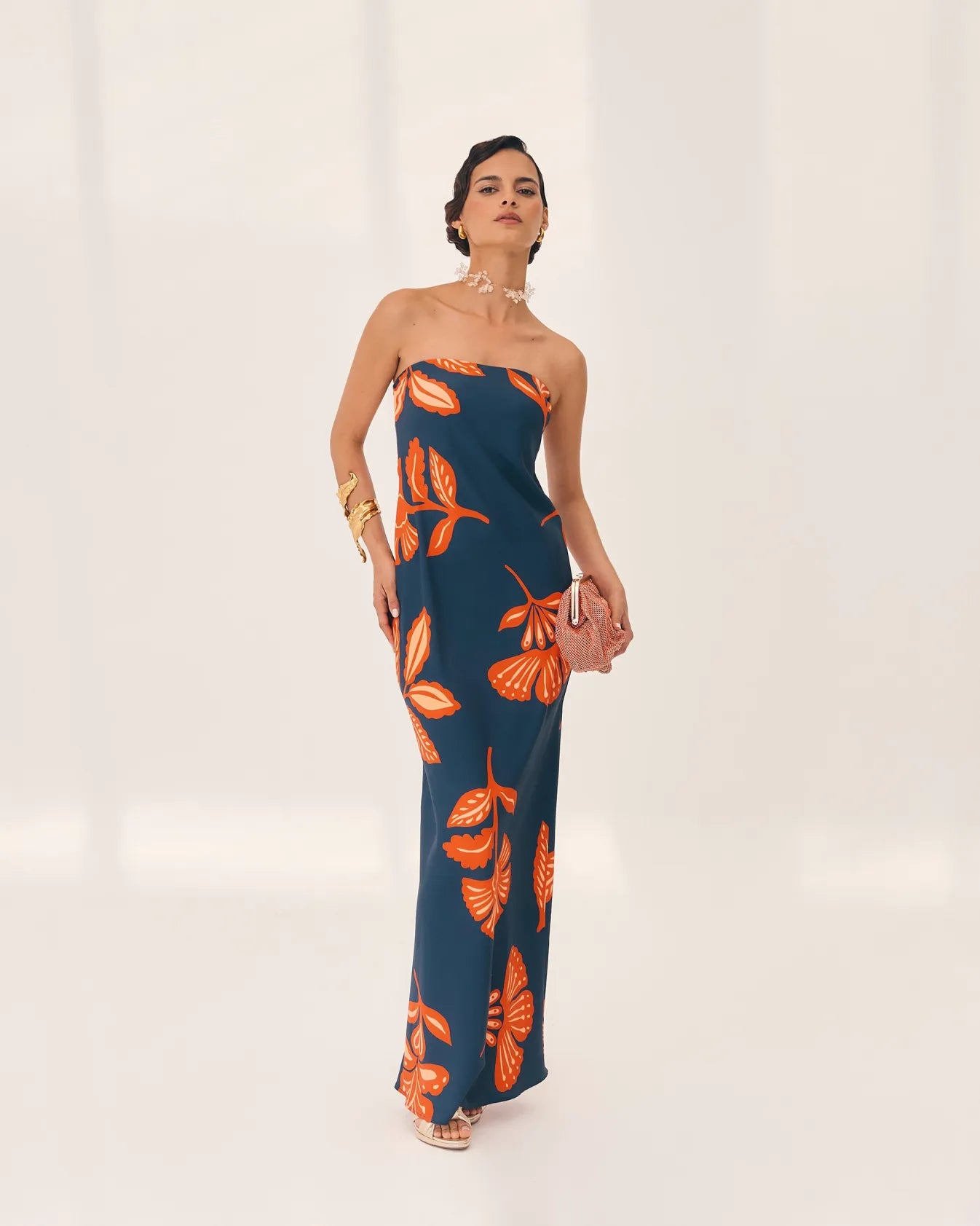Embrace elegance with the Orfila Manila Maxi Dress, featuring a strapless floral print that captures the essence of summer sophistication. Its sleeveless, backless design paired with a flowing silhouette offers a flattering, graceful fit perfect for beach parties or evening events. Complete with a coordinating scarf, this dress combines comfort and style for unforgettable holiday moments.