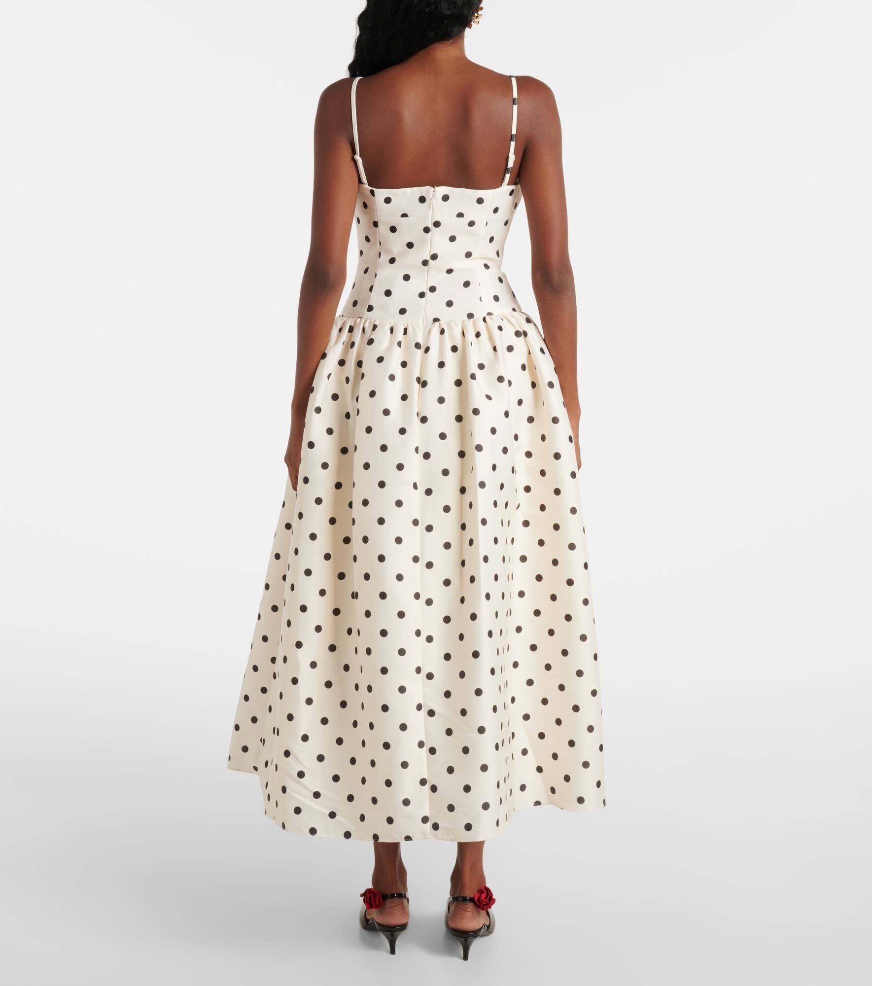 Embody timeless elegance with the Polka-dot taffeta corset dress, inspired by the refined silhouettes of the 1950s. Crafted from lustrous taffeta adorned with a delicate polka-dot motif, this dress features a structured bodice and a carefully gathered waist that accentuates a graceful silhouette. The voluminous skirt enhances movement, creating a sophisticated statement suitable for any distinguished occasion. 