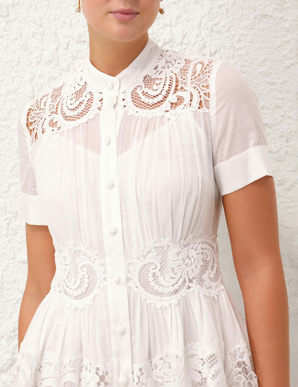 This cotton mini dress features short sleeves and a front center placket for a polished look. Its delicate scalloped hemline and intricate placement trim add refined detailing, while the included separate slip ensures comfortable coverage and smooth layering. Ideal for warm weather, this dress combines breathable fabric with elegant design elements.