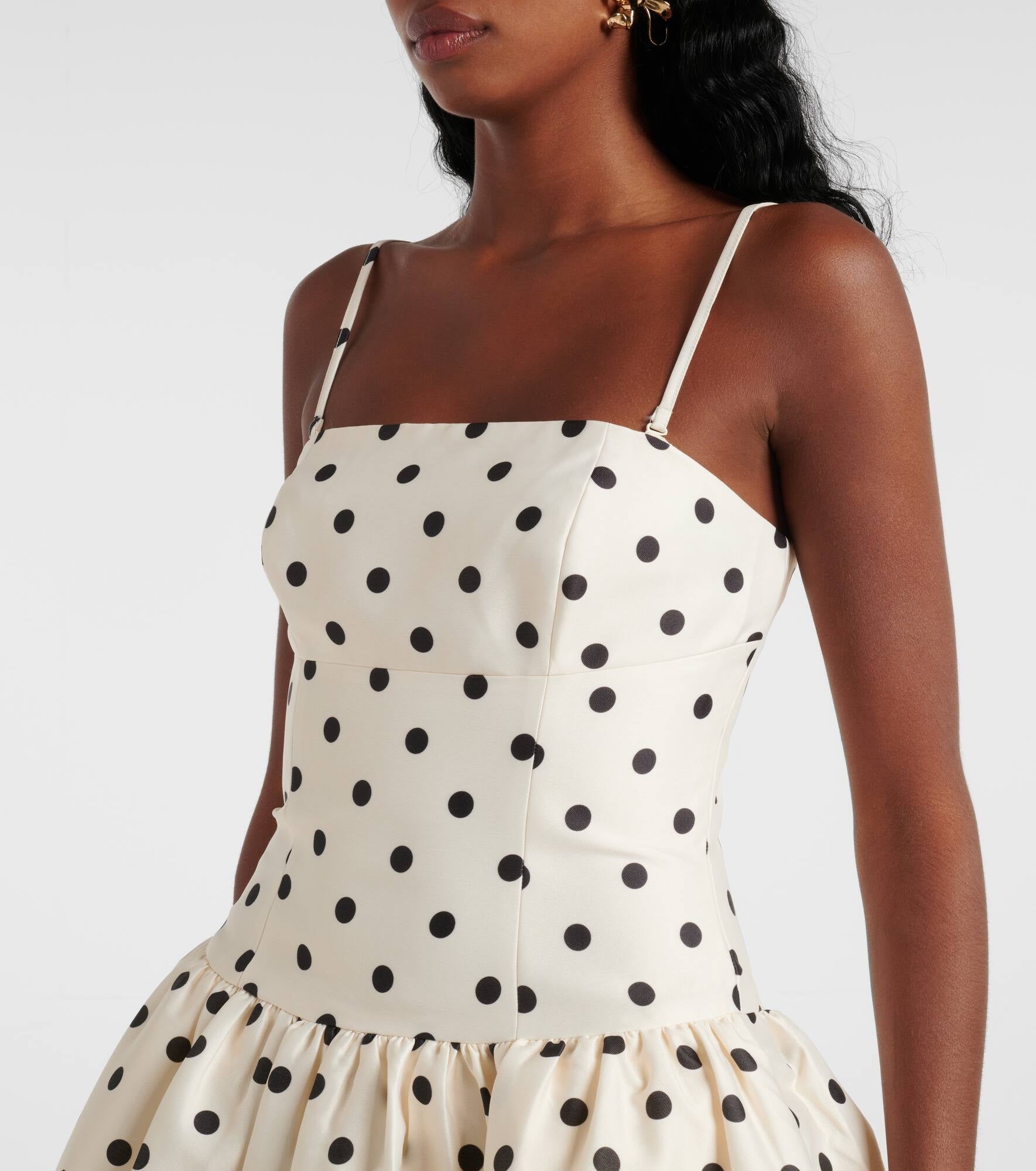 Embody timeless elegance with the Polka-dot taffeta corset dress, inspired by the refined silhouettes of the 1950s. Crafted from lustrous taffeta adorned with a delicate polka-dot motif, this dress features a structured bodice and a carefully gathered waist that accentuates a graceful silhouette. The voluminous skirt enhances movement, creating a sophisticated statement suitable for any distinguished occasion. 