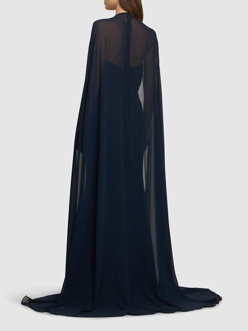 The silk blend long dress by Elie Saab features a non-detachable sheer cape that adds an elegant touch to your look. The beautiful flower appliqués at the neckline give this dress a unique and feminine vibe, perfect for that special occasion. Made of a high-quality silk in a flattering navy color, this dress is available in a range of sizes to suit every body type.