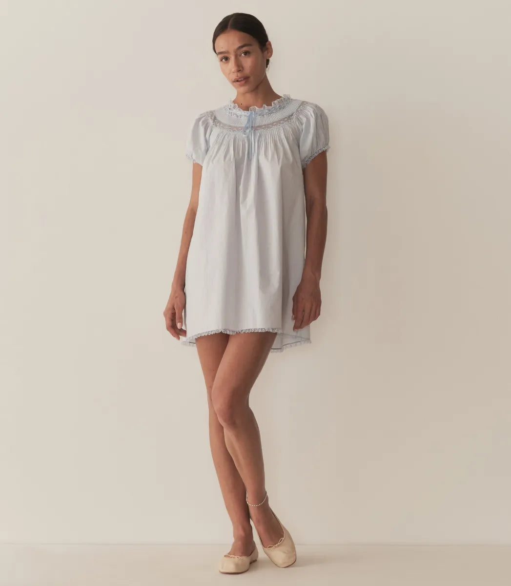 The Daphne Dress by Doen combines refined craftsmanship with effortless style, made from crisp organic cotton poplin for breathability and comfort. Its A-line silhouette and mini-length hem create a light, playful shape, while short puffed sleeves add subtle volume. Detailed with floral scallop lace, delicate pintucks, and a grosgrain ribbon tie at the yoke, this dress is completed with lace trims on the cuffs and hem. Ideal for warm weather occasions, it balances casual ease with elegant detailing.