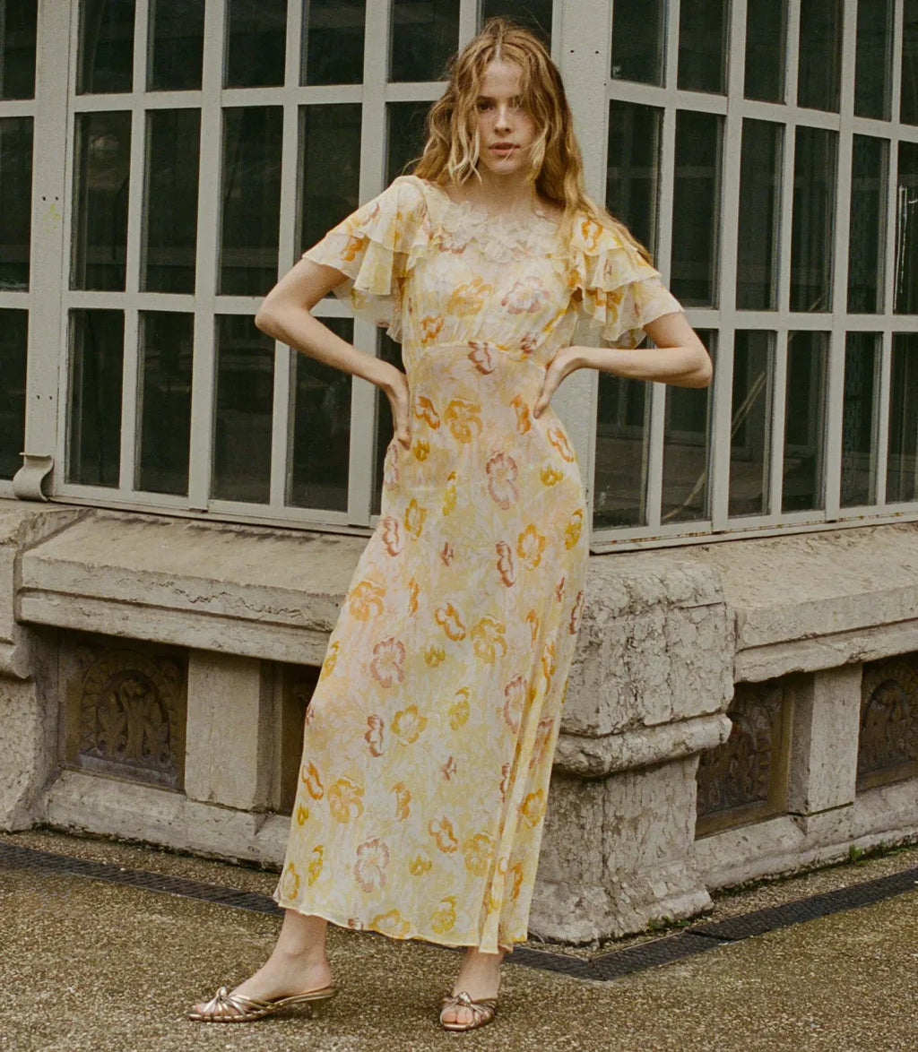 Indulge in timeless elegance with the ethereal Doen Nevara Dress. Made of delicate silk with cascading ruffles and silk organza flowers, this ‘30s-inspired design features an invisible side zipper and bias-cut floor-length skirt. Perfect for special occasions, it combines vintage charm with modern sophistication.