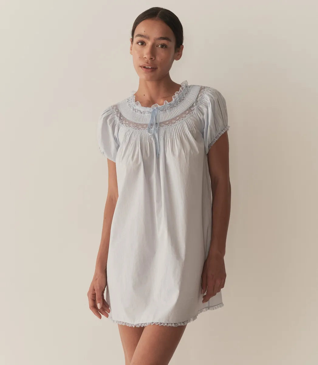 The Daphne Dress by Doen combines refined craftsmanship with effortless style, made from crisp organic cotton poplin for breathability and comfort. Its A-line silhouette and mini-length hem create a light, playful shape, while short puffed sleeves add subtle volume. Detailed with floral scallop lace, delicate pintucks, and a grosgrain ribbon tie at the yoke, this dress is completed with lace trims on the cuffs and hem. Ideal for warm weather occasions, it balances casual ease with elegant detailing.