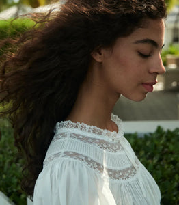 The Daphne Dress by Doen combines refined craftsmanship with effortless style, made from crisp organic cotton poplin for breathability and comfort. Its A-line silhouette and mini-length hem create a light, playful shape, while short puffed sleeves add subtle volume. Detailed with floral scallop lace, delicate pintucks, and a grosgrain ribbon tie at the yoke, this dress is completed with lace trims on the cuffs and hem. Ideal for warm weather occasions, it balances casual ease with elegant detailing.