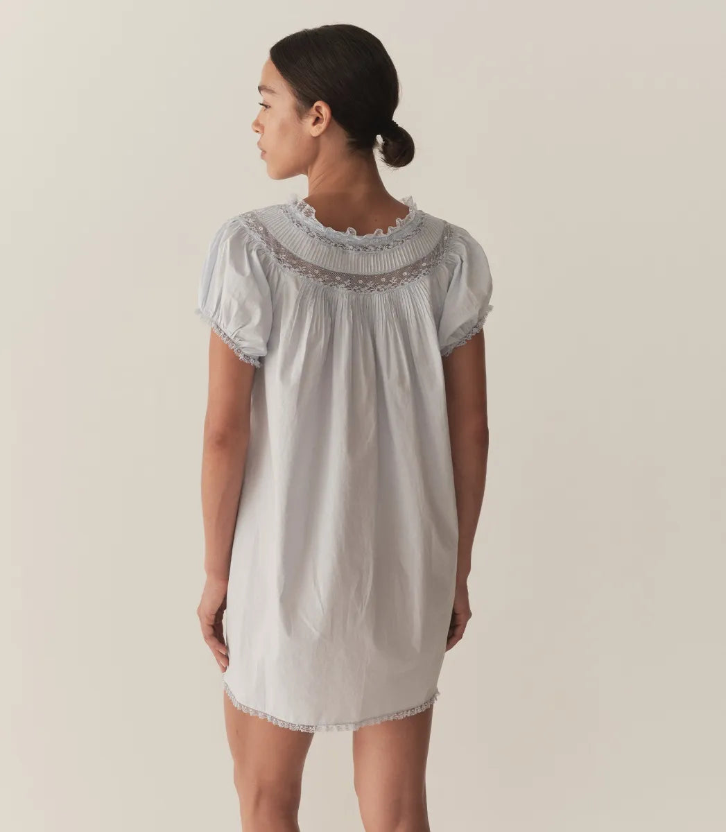 The Daphne Dress by Doen combines refined craftsmanship with effortless style, made from crisp organic cotton poplin for breathability and comfort. Its A-line silhouette and mini-length hem create a light, playful shape, while short puffed sleeves add subtle volume. Detailed with floral scallop lace, delicate pintucks, and a grosgrain ribbon tie at the yoke, this dress is completed with lace trims on the cuffs and hem. Ideal for warm weather occasions, it balances casual ease with elegant detailing.