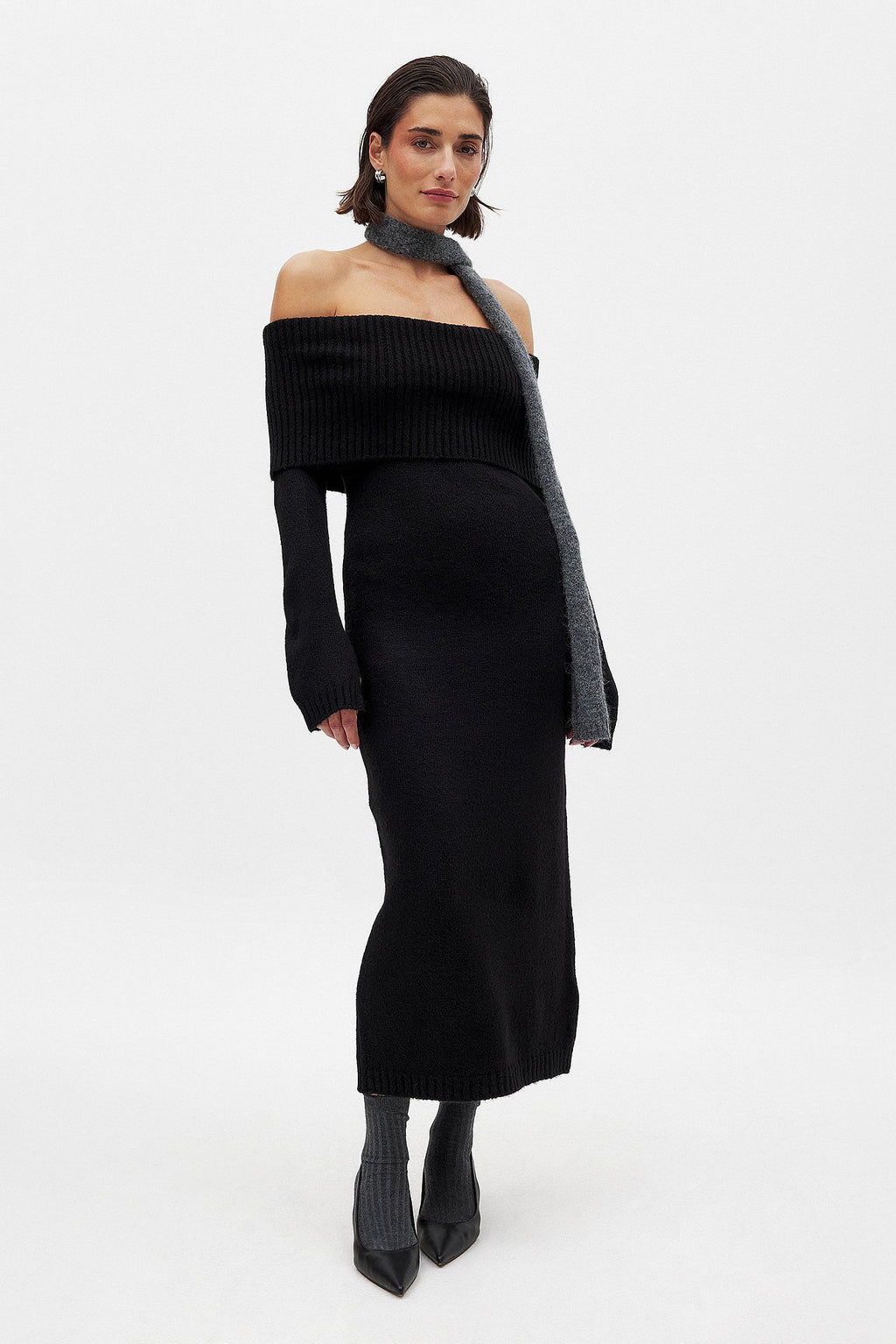 This knitted midi dress offers a perfect balance of comfort and sophistication. Crafted from stretchy knit fabric, it ensures ease of movement with a relaxed fit. The folded off-shoulder neckline adds an elegant flair, complemented by long sleeves featuring subtle slit details for a refined, contemporary look. Ideal for sophisticated casual occasions, this dress delivers effortless style without compromising on wearability.