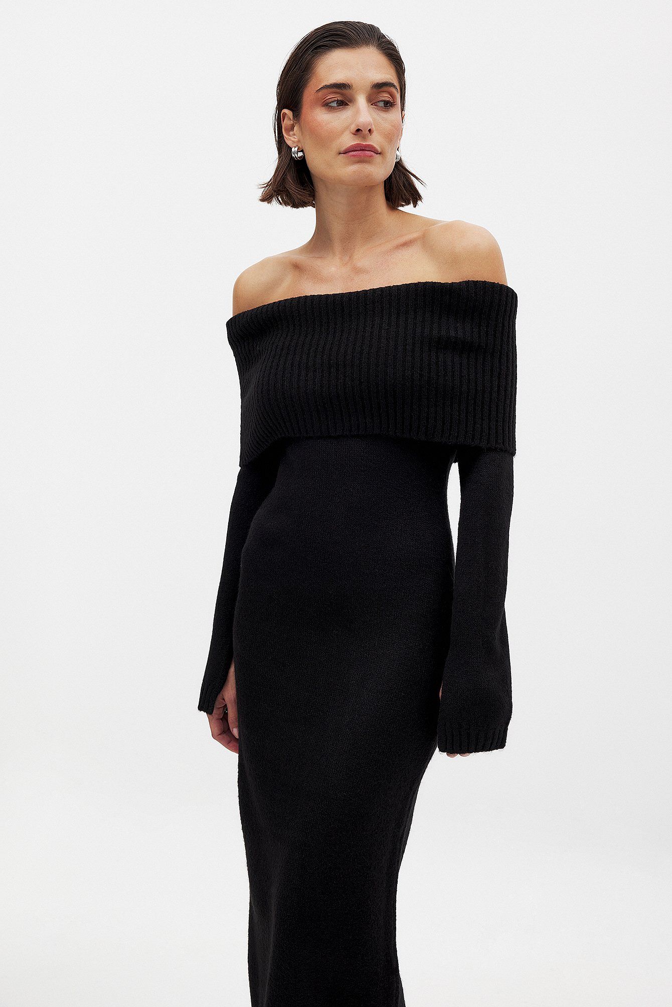 This knitted midi dress offers a perfect balance of comfort and sophistication. Crafted from stretchy knit fabric, it ensures ease of movement with a relaxed fit. The folded off-shoulder neckline adds an elegant flair, complemented by long sleeves featuring subtle slit details for a refined, contemporary look. Ideal for sophisticated casual occasions, this dress delivers effortless style without compromising on wearability.