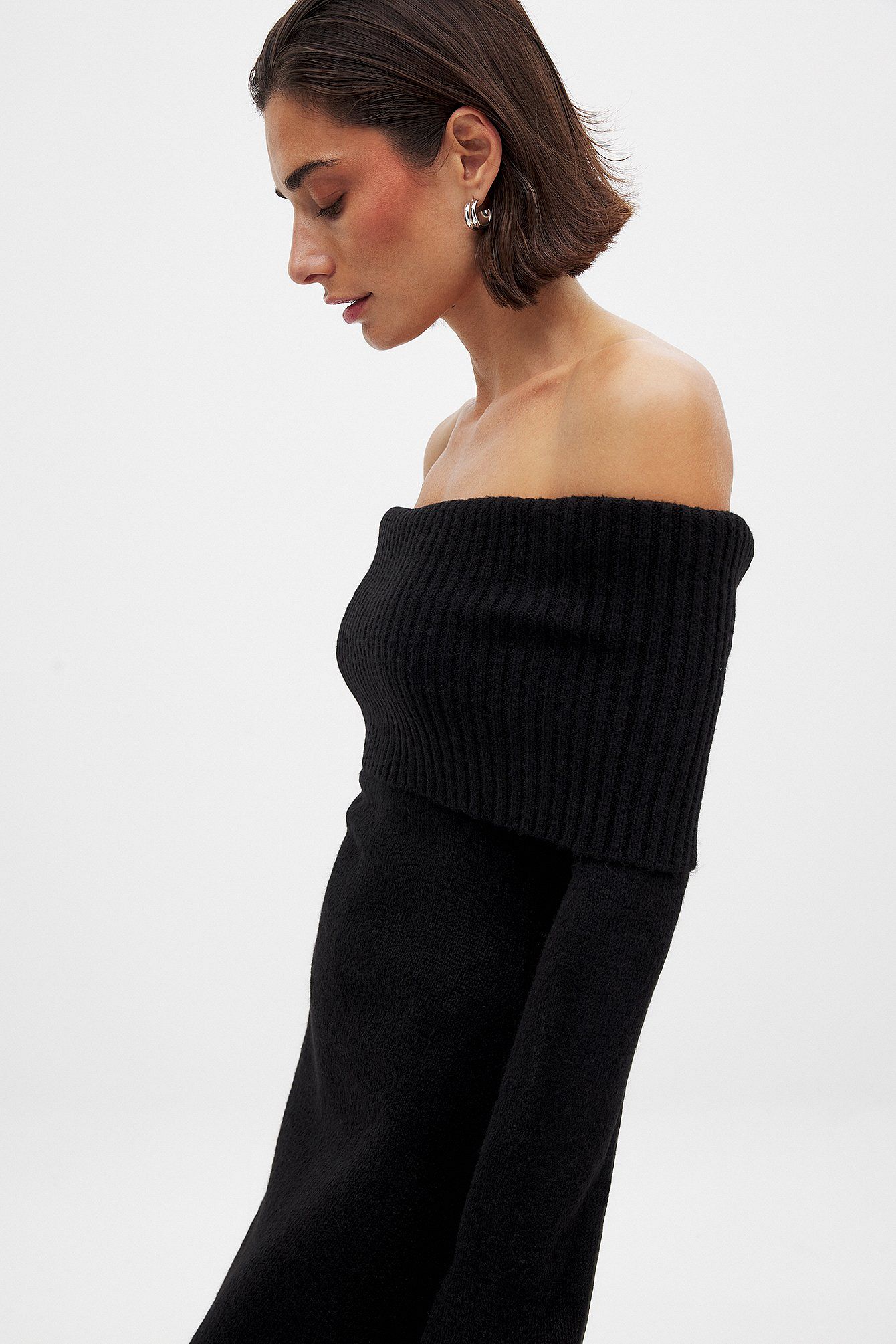 This knitted midi dress offers a perfect balance of comfort and sophistication. Crafted from stretchy knit fabric, it ensures ease of movement with a relaxed fit. The folded off-shoulder neckline adds an elegant flair, complemented by long sleeves featuring subtle slit details for a refined, contemporary look. Ideal for sophisticated casual occasions, this dress delivers effortless style without compromising on wearability.