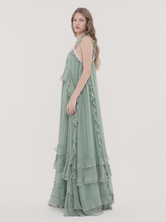 Iconic organic silk mousseline layered long dress with refined elegance. Features a delicate V-shaped lace insert, romantic ruffles, and an adjustable drawstring neckline for flattering fit. Sleeveless silhouette offers versatility for layering or solo wear. Silk-mix lining provides comfort and drape. Perfect for special occasions or elevated everyday styling.