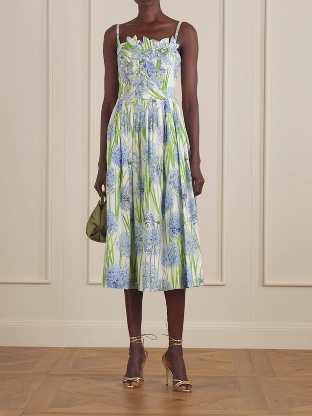 Discover timeless elegance with this Oscar de la Renta midi dress, where artistry meets everyday wear. The bodice features hand-appliquéd blooms that echo the vibrant floral print, creating dimensional depth and visual interest. Crafted from a soft cotton-blend poplin, this piece offers comfort without compromise. The square neckline frames the shoulders beautifully, while gentle pleats through the hem add graceful volume and movement. 