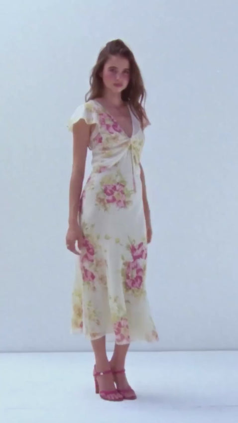 Meet the Meg — an effortlessly elegant sheer tea dress that skims your silhouette with graceful movement. The flattering V neckline features softly draped fabric at the bust, adorned with a delicate floral corsage positioned close to the heart. Midi length with airy cap sleeves, this dress floats beautifully against the body, offering just the right amount of sheer coverage. Wear it demure with the included slip, or embrace a bolder look without — the versatility is yours to command.