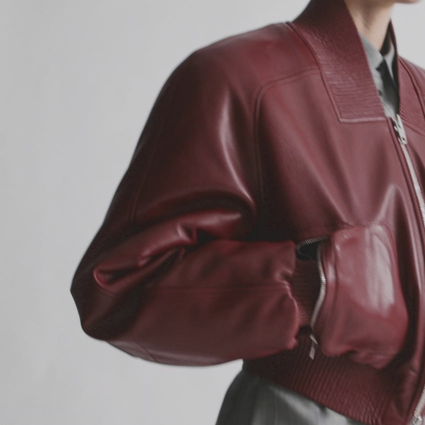 Elevate your outerwear collection with this striking brick leather bomber jacket by Phoebe Philo, designed for those who refuse to compromise on style or functionality. The cropped silhouette flatters every frame, while strategically placed zipped moulded pockets on the body and sleeves keep your essentials secure and accessible. Luxurious glossed nappa leather is lightly padded to provide genuine warmth without bulk, ensuring comfort through unpredictable weather. 