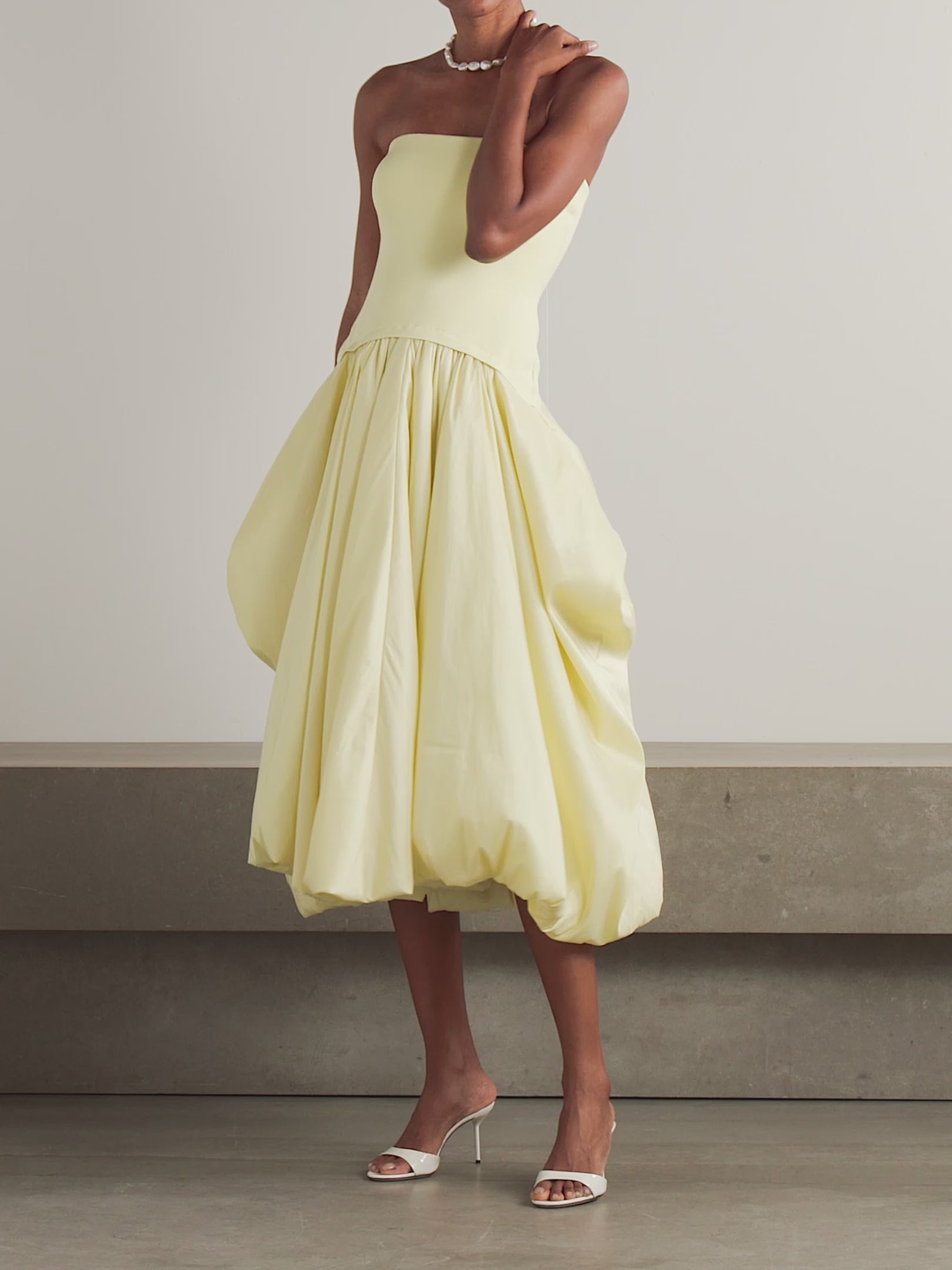Experience elegance with SIMKHAI’s Izzy Stretch-knit and Gathered Taffeta Midi Dress. Featuring a fitted stretch-knit bodice and a voluminous taffeta skirt in a radiant Sunglow yellow, this strapless design sculpts your silhouette with a gathered waist and an eye-catching asymmetric bubble hem. Perfectly balanced and uniquely stylish, it’s an unforgettable choice for making a bold, sophisticated statement.