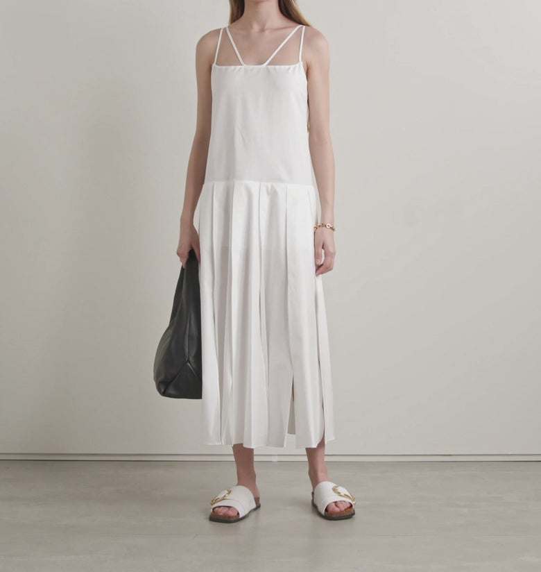 Slip into effortless elegance with the Thea maxi dress, where thoughtful design meets tactile luxury. Crafted from feather-light cotton-poplin, this spring essential features a dropped waist that gracefully transitions into a flowing pleated skirt—perfect for twirling through your day. The signature double straps create an intriguing illusion of cutouts at the chest and crisscross dramatically down the back, adding just the right amount of playful intrigue. 