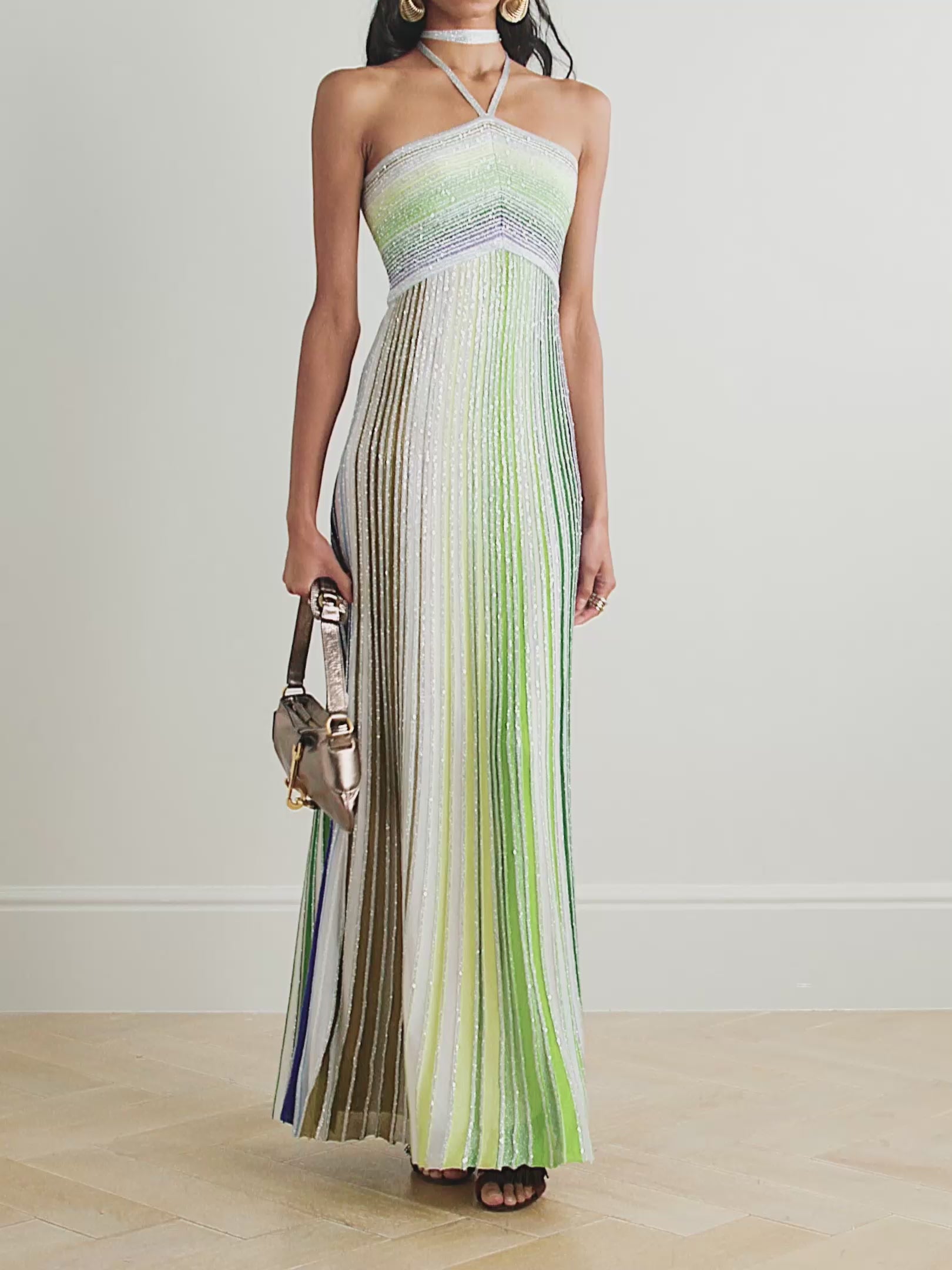 Missoni’s Sequin-embellished Metallic Crochet-knit Halterneck Maxi Dress elevates occasion dressing with vibrant style. Crafted in Italy with metallic threads, its vivid striped pattern catches the eye, while shimmering sequins add an elegant sparkle. The silver halterneck strap beautifully frames the collarbones, making this dress a stunning choice for any special event.