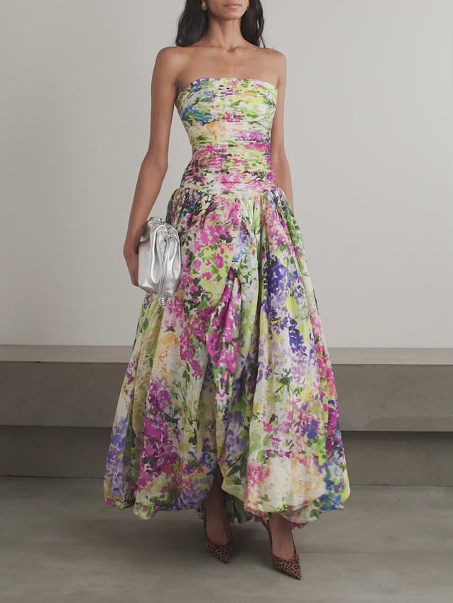Aje's strapless Dahlia gown captures the essence of the Impressionist Resort '26 collection, where nature-inspired design meets refined tailoring. Crafted from a breathable Lyocell blend, this statement piece features a fitted, pintucked bodice that sculpts the silhouette before flowing into a voluminous bubble skirt. Artful floral prints evoke painterly blooms, creating movement and visual depth with every step. 