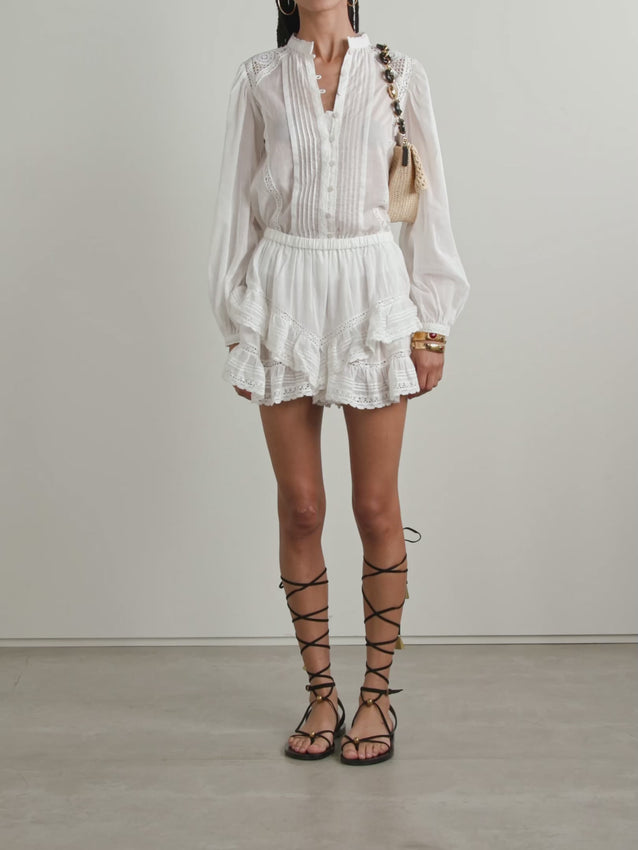 Embrace your inner romantic with these whimsical Geana shorts, where vintage bloomers meet modern style. Crafted from breathable cotton-voile, they feature a flattering elasticated waistband and cascading tiers of ruffles adorned with delicate lace trim. Perfect for adding a touch of nostalgic charm to warm-weather outfits, these flouncy shorts deliver comfort without compromising on character.