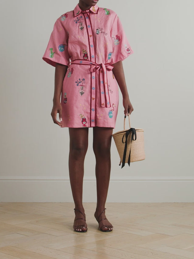 Discover the artistry of Alémais' Timmy mini dress, a wearable celebration of creativity and imagination. This relaxed shirt-style design features vibrant printed and embroidered motifs crafted by renowned artist Nadia Hernandez, each detail telling a story of cherished memories. Cut from breathable linen for effortless comfort, the dress showcases elegant burgundy trims that add sophistication. Cinch the waist with the included matching belt to create your perfect silhouette. 