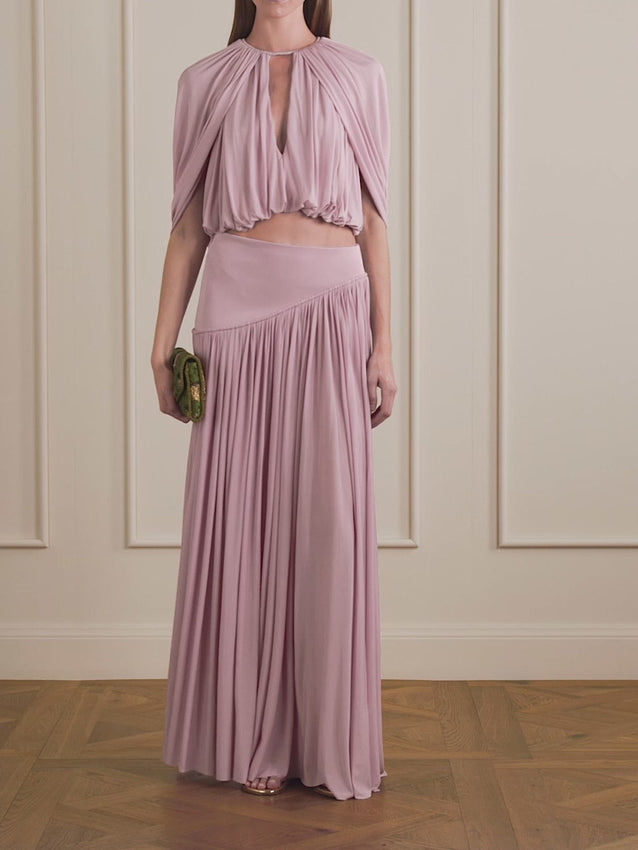 Soft light pink crepe flows into an elegant maxi silhouette with asymmetric draping and subtle gathering that enhances every movement. The Alchemy skirt balances refined sophistication with relaxed fluidity—a versatile piece that transitions seamlessly from special occasions to everyday wear. The lightweight, slightly stretchy fabric skims the body with understated grace.