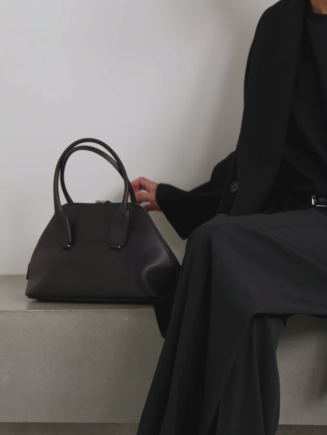 The Devon medium leather tote combines understated elegance with everyday practicality. Handcrafted in Italy from supple leather, this geometric tote features robust top handles and a thoughtfully proportioned interior perfect for daily essentials—phone, wallet, sunglasses, and more. Its refined silhouette transitions seamlessly from work to weekend, making it an investment piece that anchors any wardrobe with timeless sophistication.