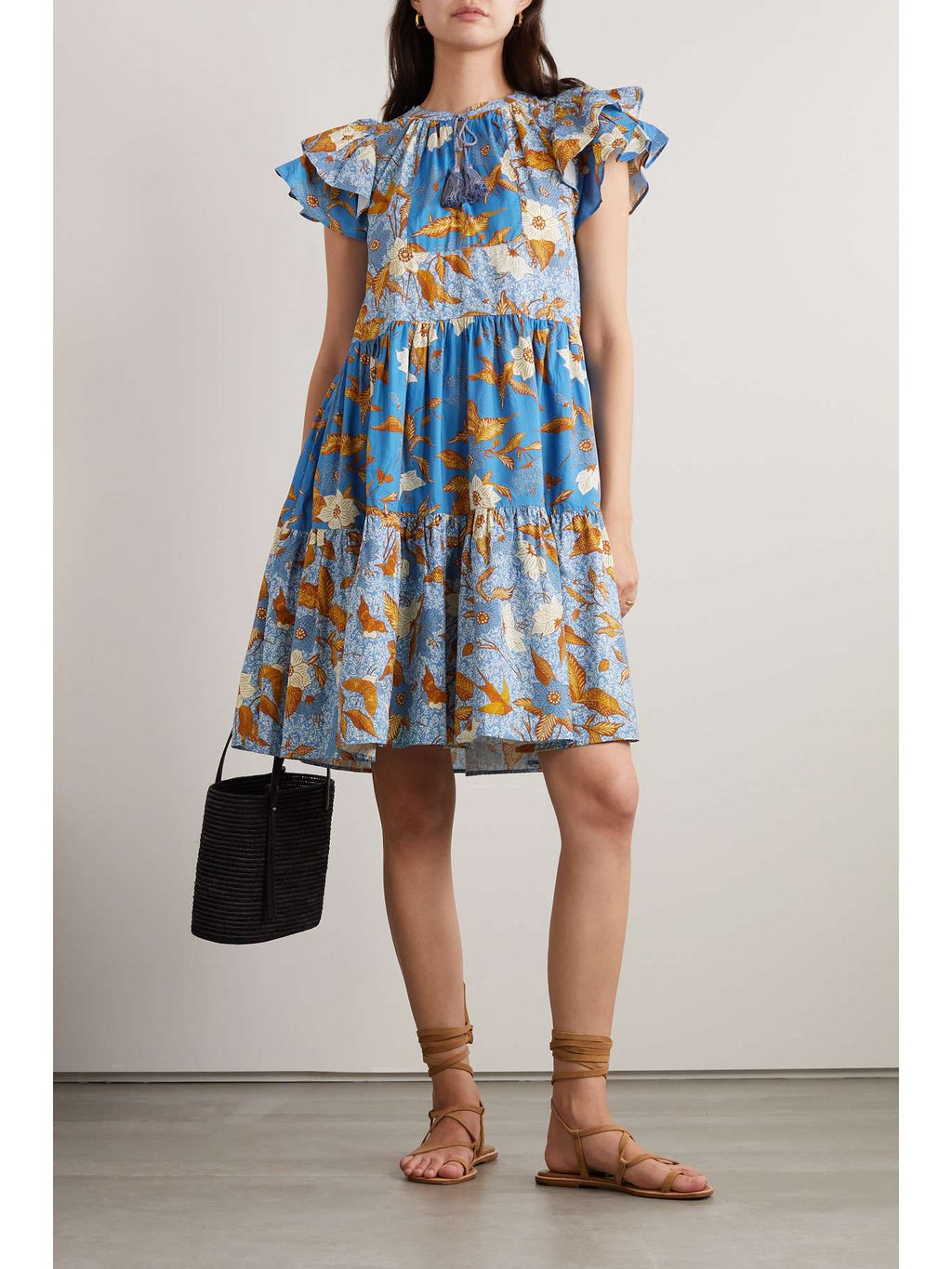 Indulge in the whimsical charm of our Gail Ruffled Patchwork Dress. Adorned with a lovely patchwork design of hibiscus flowers and birds, this dress is made from a lightweight cotton-blend with ruffled sleeves and a tiered skirt. Let the delicate tasselled ties dangle freely while showcasing a beautiful pendant. Embrace the ethereal beauty of this dress and turn heads wherever you go!