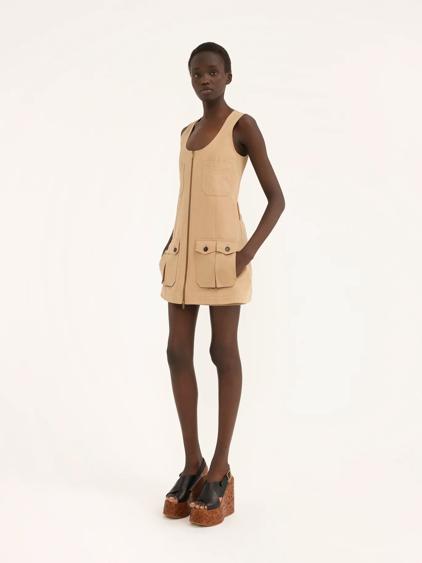 Expertly crafted from soft organic cotton gabardine, this Saharienne Dress from Chloé features practical expandable pockets, a functional front zipper, and stylish back button tabs. Stay comfortable and chic all day while minimizing your environmental impact.